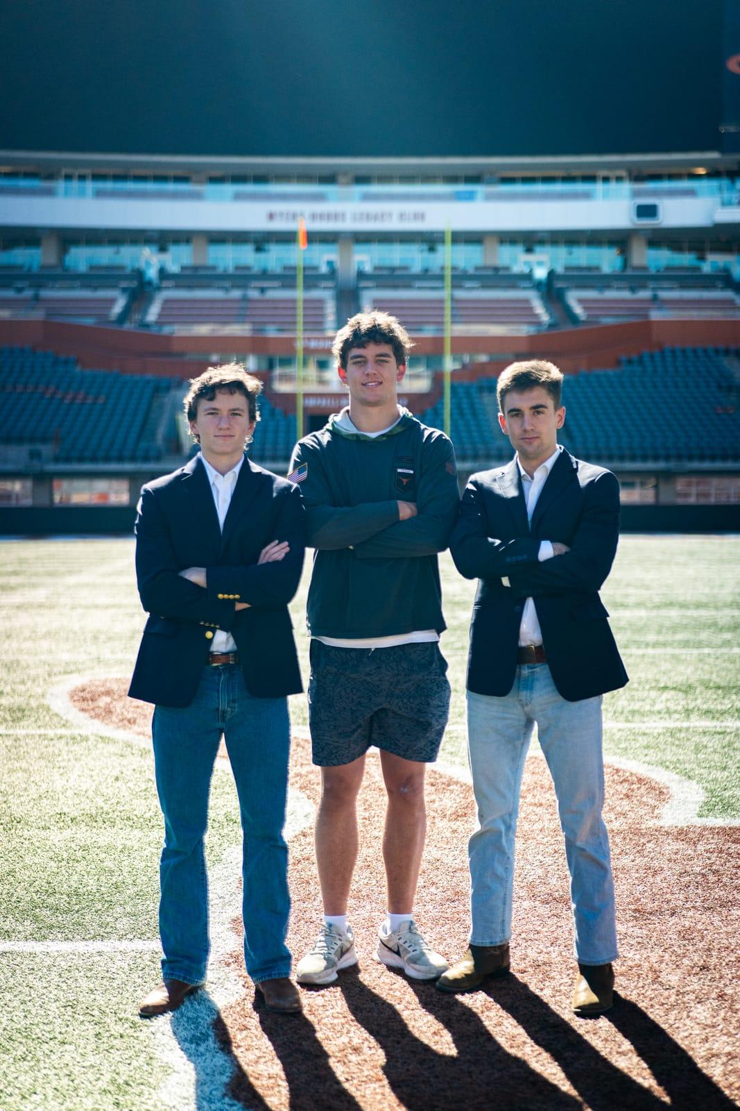 Armando, Ben, and the team standing strong with arms crossed on the field