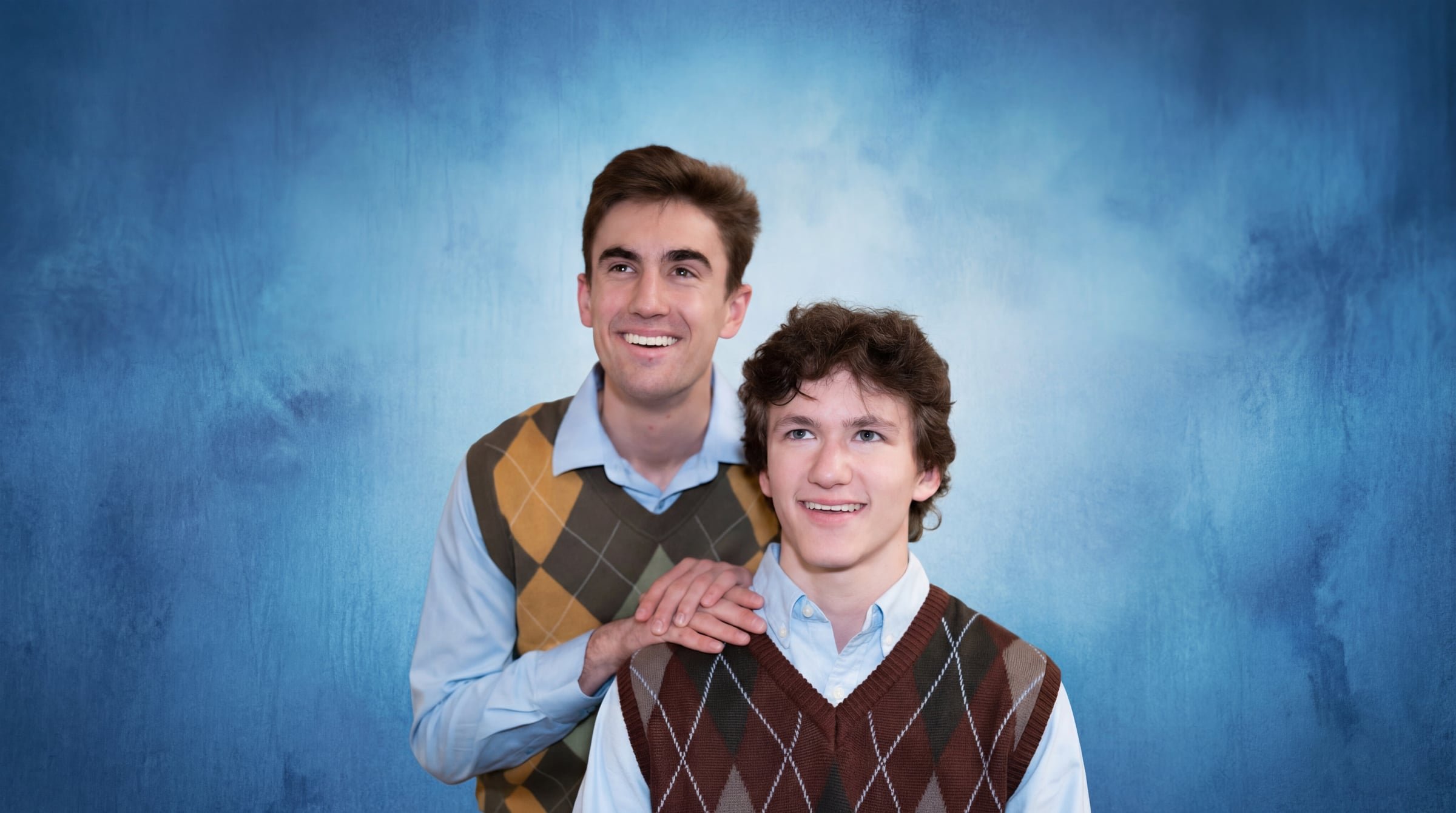 Armando and Ben in matching argyle sweater vests, school photo style portrait